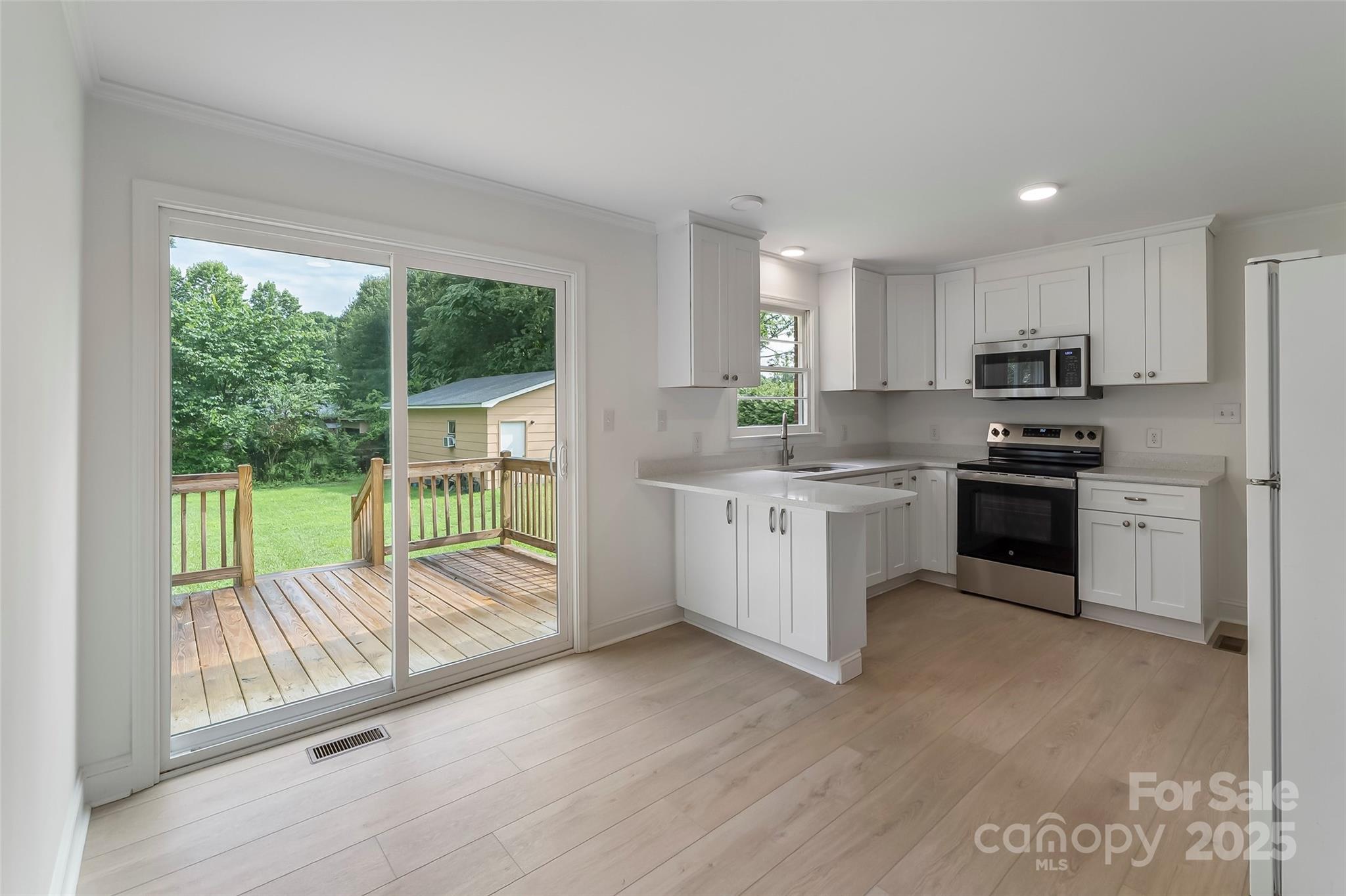 4146 Old State Road Newton, NC 28658 - Photo 6 of 26 a kitchen with kitchen island a large window appliances and cabinets