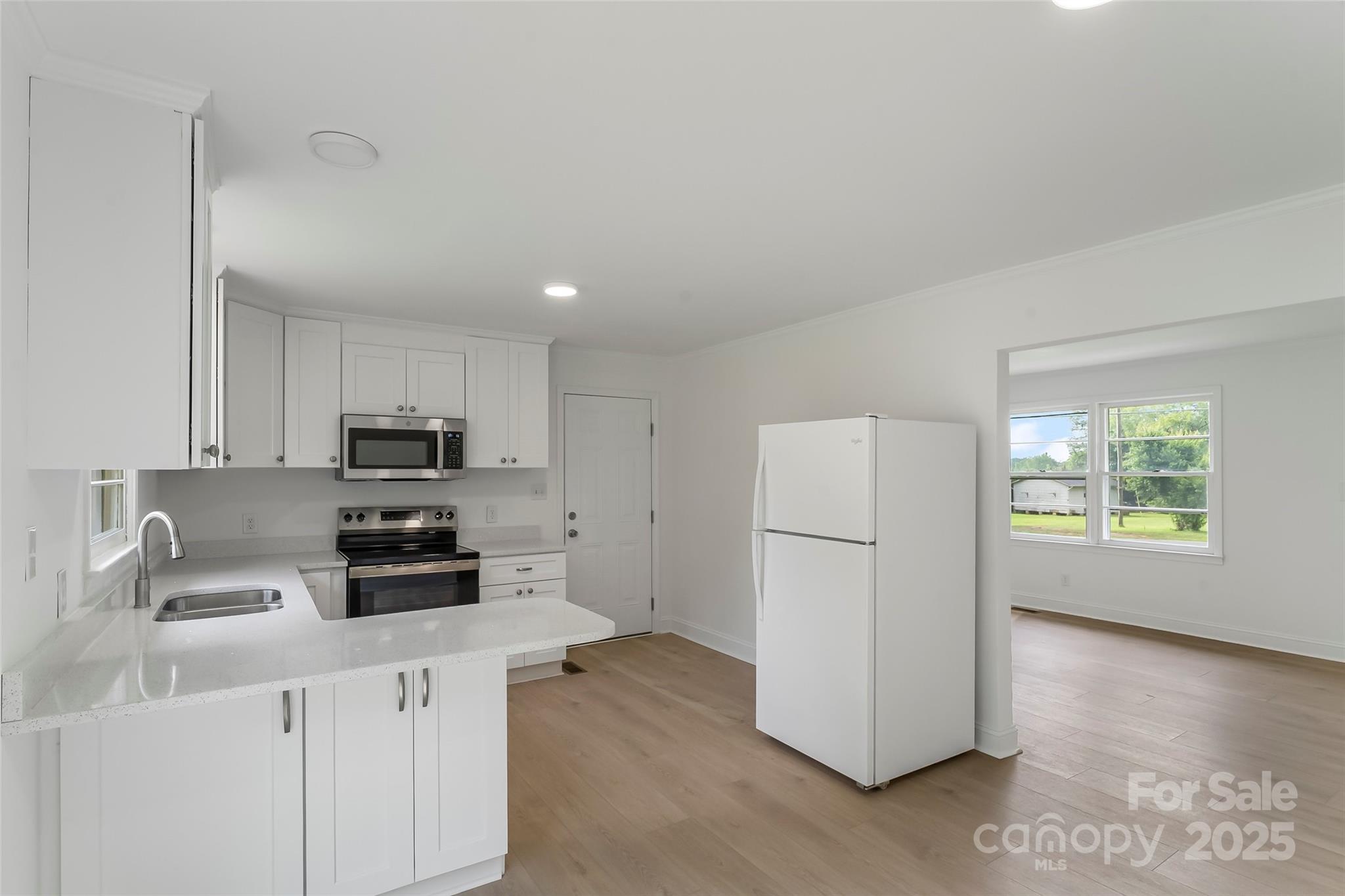 4146 Old State Road Newton, NC 28658 - Photo 7 of 26 a kitchen with a refrigerator a stove a sink a center island and a window