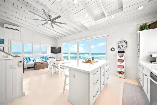 a kitchen filled with white cabinets a sink appliances and a counter top space
