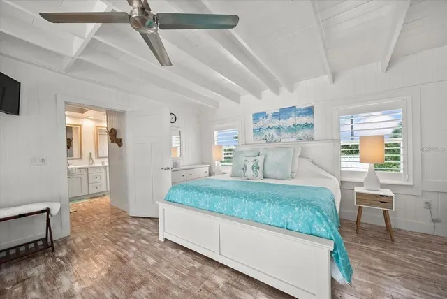 a bedroom with a large bed and large windows