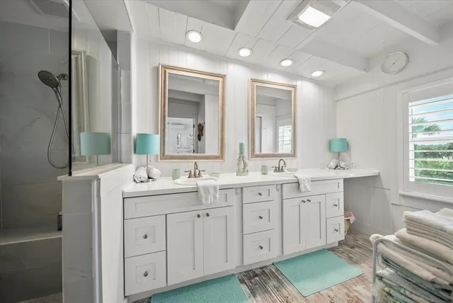 a bedroom with a bed and a large mirror on the dresser