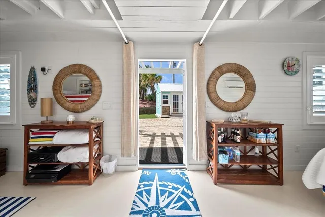 a room with lots of white furniture and paintings on the wall