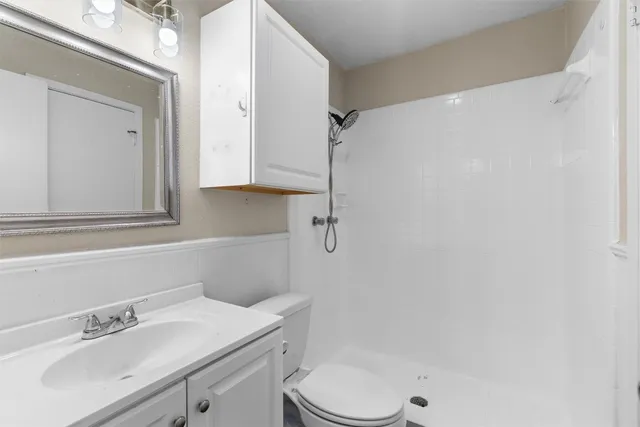 a bathroom with a sink a toilet and shower