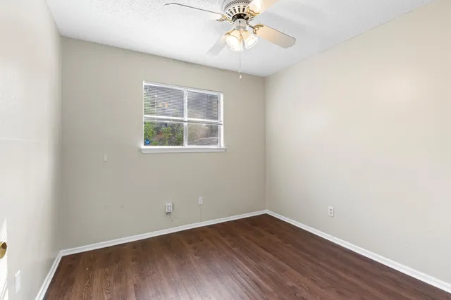 an empty room with a window and wooden floor