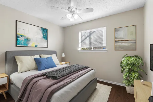 a bedroom with a bed and a painting on the wall