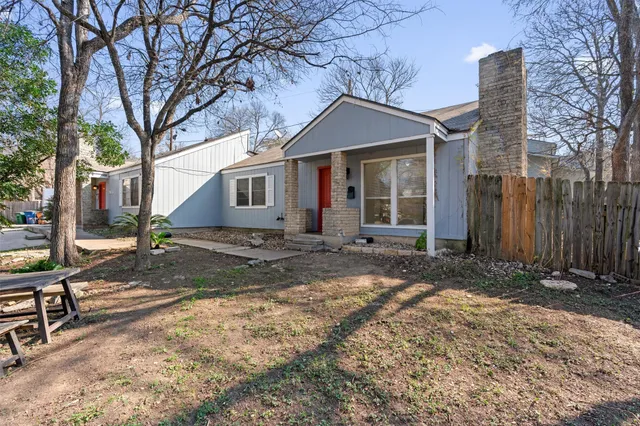 a view of a house with backyard and trees