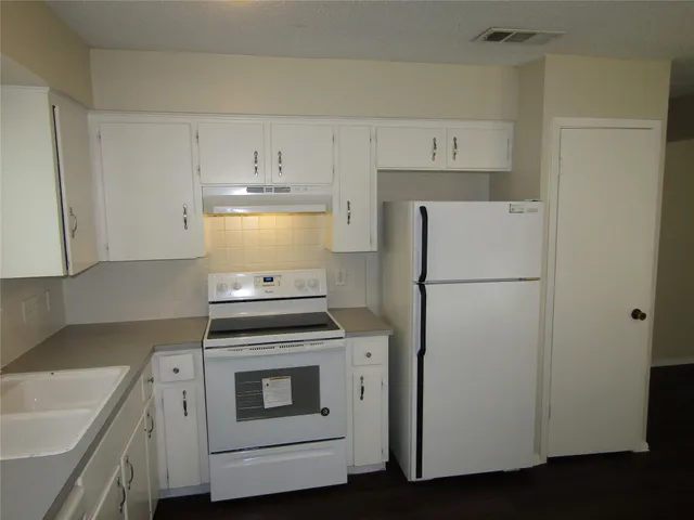 a kitchen with cabinets and white appliances