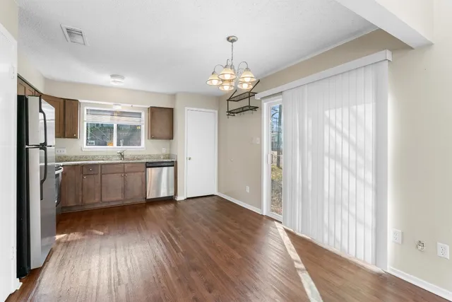 a view of a kitchen with a sink a refrigerator and wooden floor