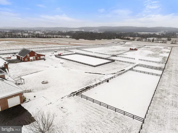 a kitchen with stainless steel appliances granite countertop a sink a stove a refrigerator cabinets a dining table and chairs