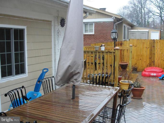 511 Waterford Road Silver Spring, MD 20901 - Photo 11 of 20 a view of a deck with table and chairs with wooden floor and fence