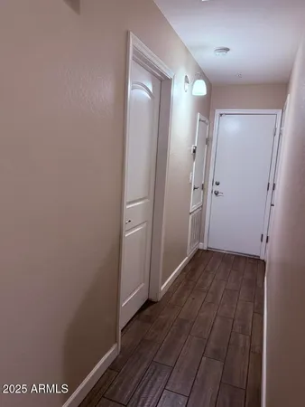 a view of a room with wooden floor and mirror