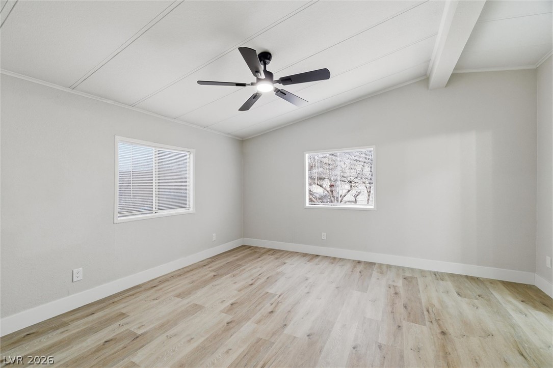 3940 Point Drive Pahrump, NV 89060 - Photo 21 of 35 A well-lit bedroom features vaulted ceilings and light wood flooring.