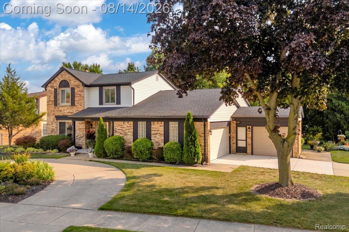 47321 Susan Road Macomb, MI 48044 - Photo 2 of 46 Brick and siding exterior with arched window detail, mature tree, manicured landscaping, and attached garage