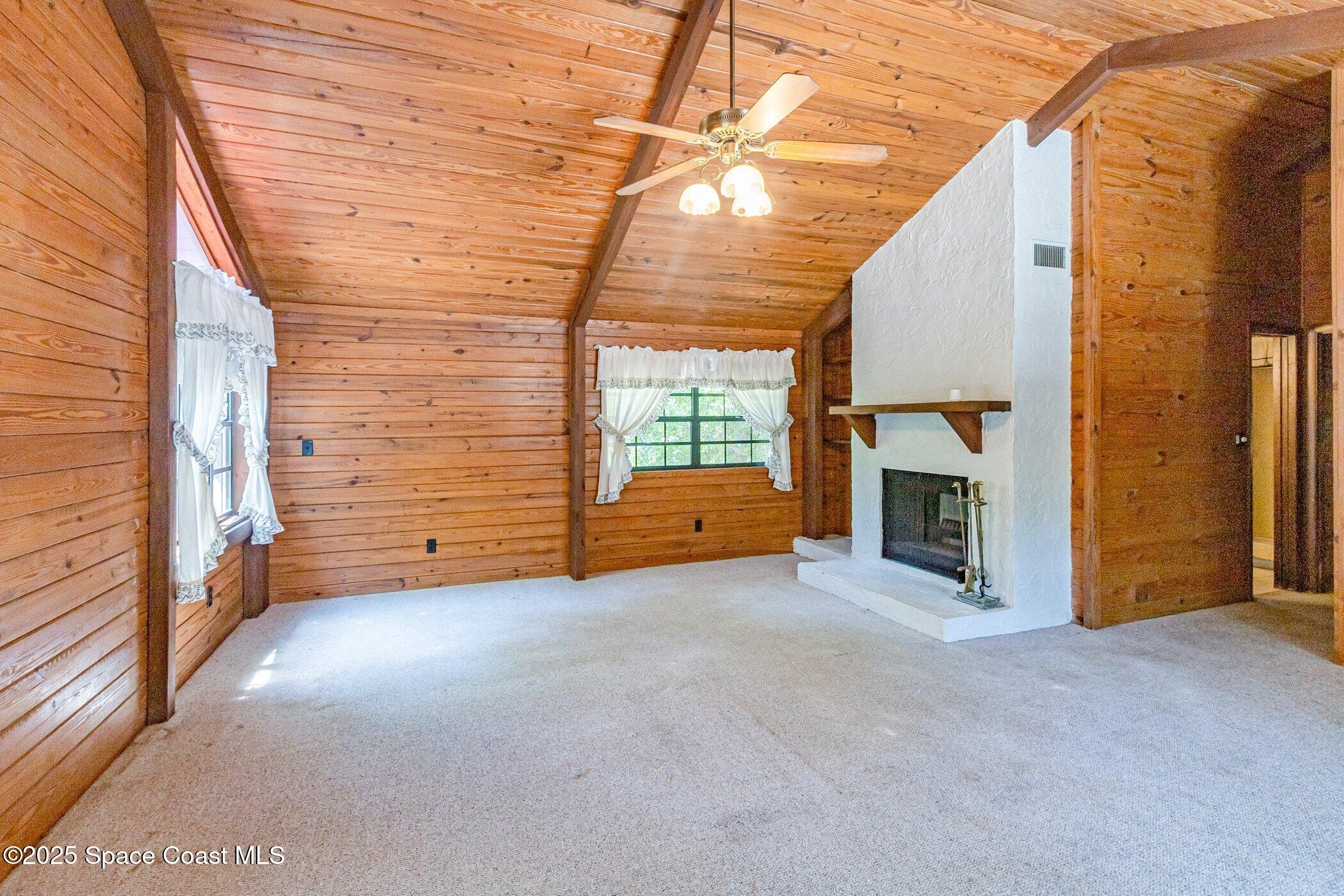 630 Chase Hammock Road Merritt Island, FL 32953 - Photo 15 of 37 a view of an empty room with a fireplace and a window