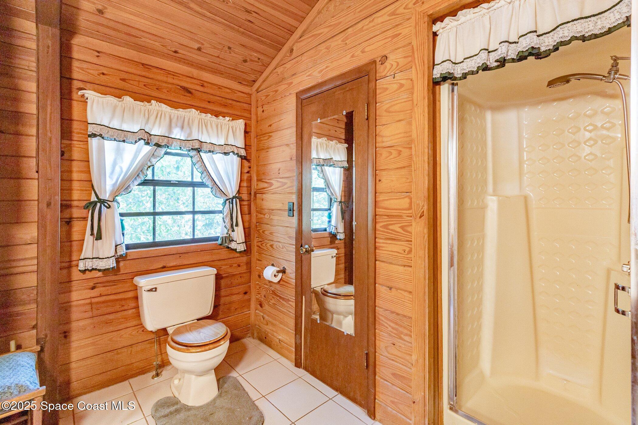 630 Chase Hammock Road Merritt Island, FL 32953 - Photo 17 of 37 a bathroom with a toilet a sink and a large window