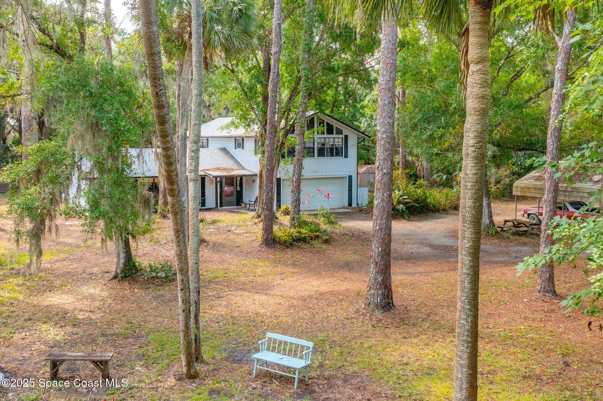 630 Chase Hammock Road Merritt Island, FL 32953 - Photo 3 of 37 a front view of a house with a yard