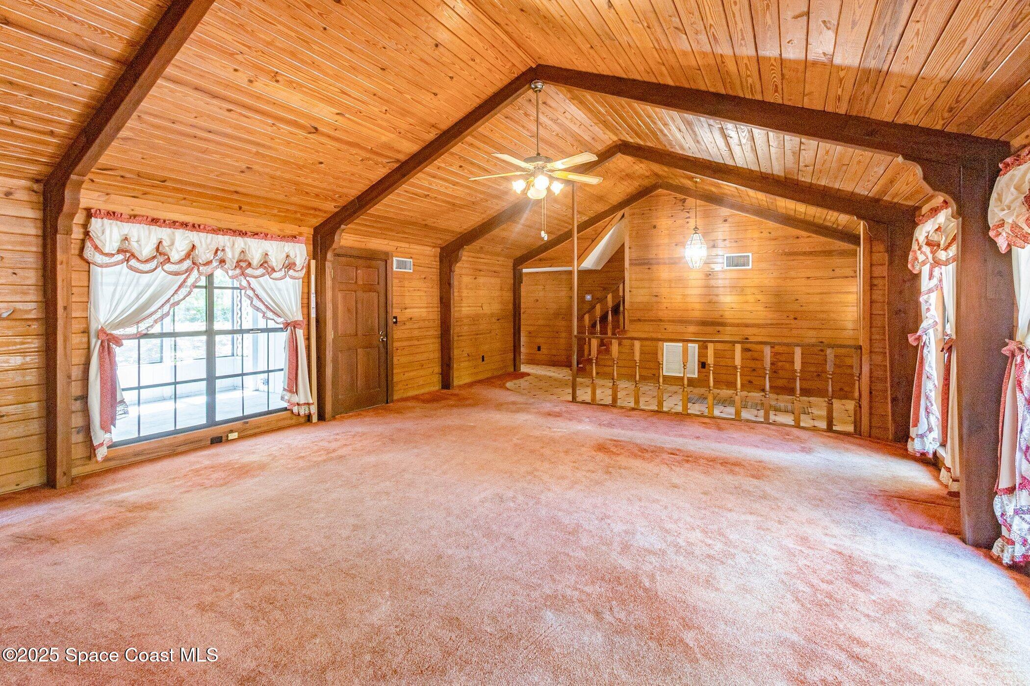 630 Chase Hammock Road Merritt Island, FL 32953 - Photo 7 of 37 an empty room with a fireplace and windows