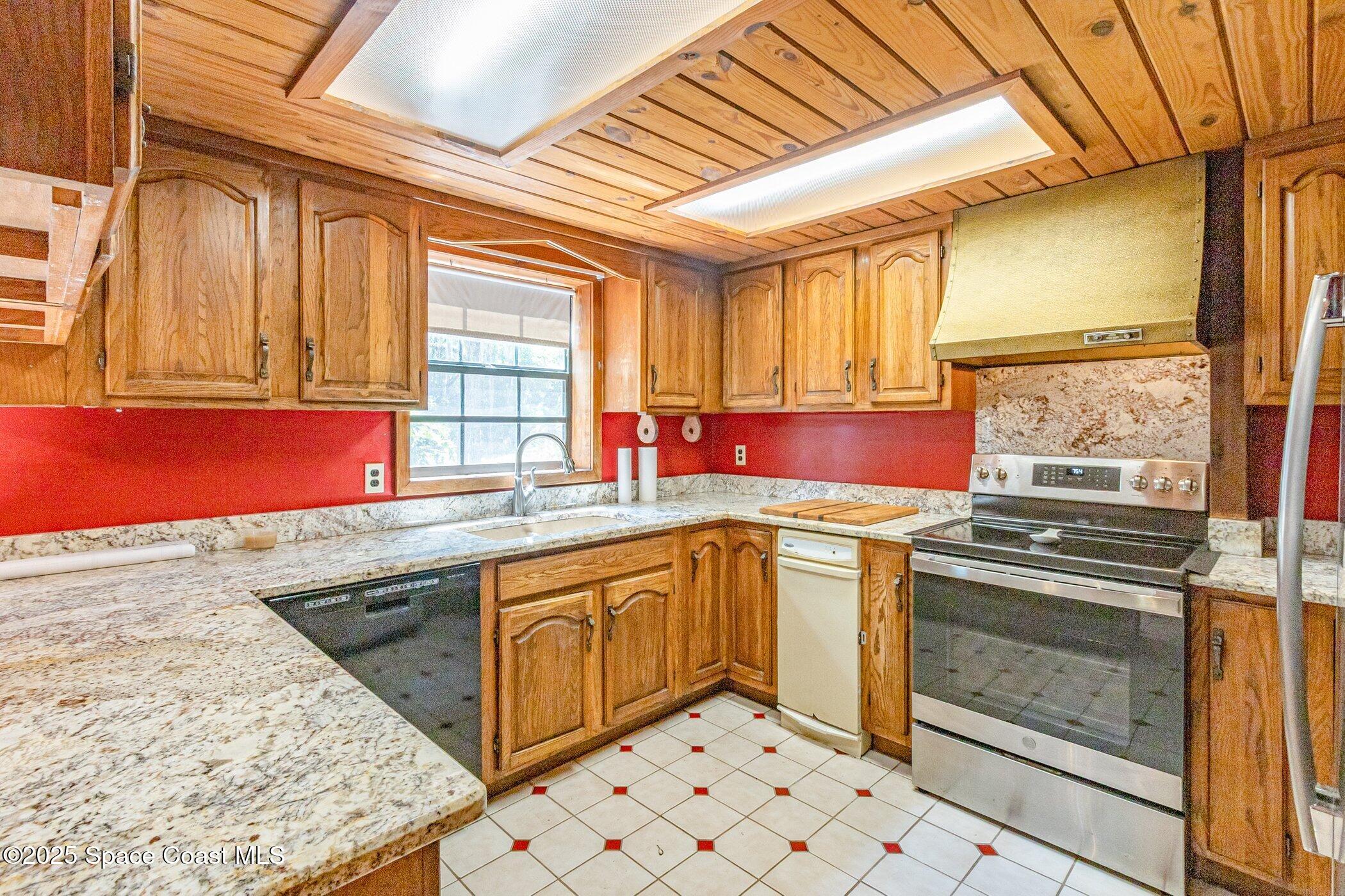 630 Chase Hammock Road Merritt Island, FL 32953 - Photo 9 of 37 a kitchen with stainless steel appliances granite countertop a sink stove and window