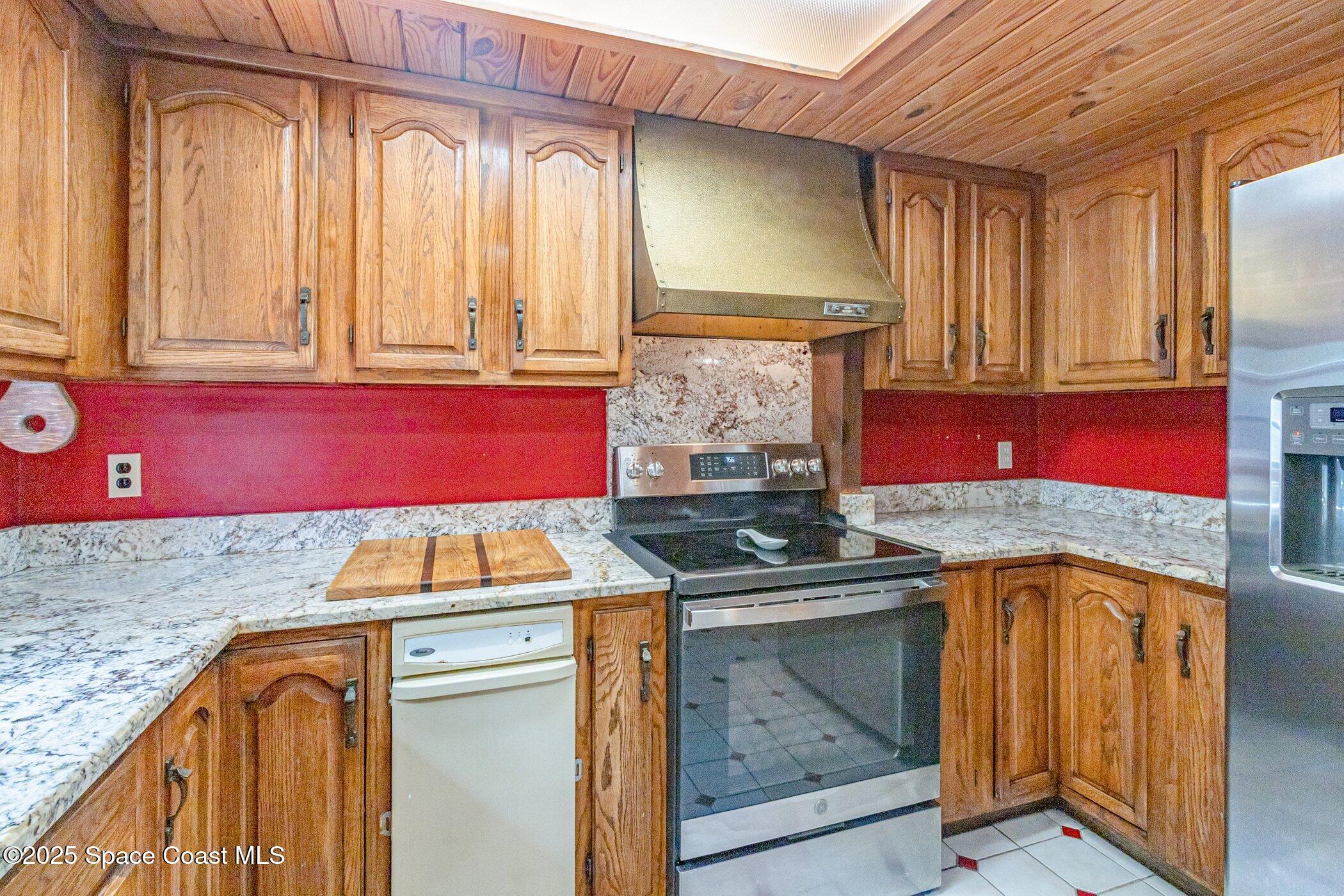 630 Chase Hammock Road Merritt Island, FL 32953 - Photo 10 of 37 a kitchen with stainless steel appliances granite countertop a stove a sink and a microwave