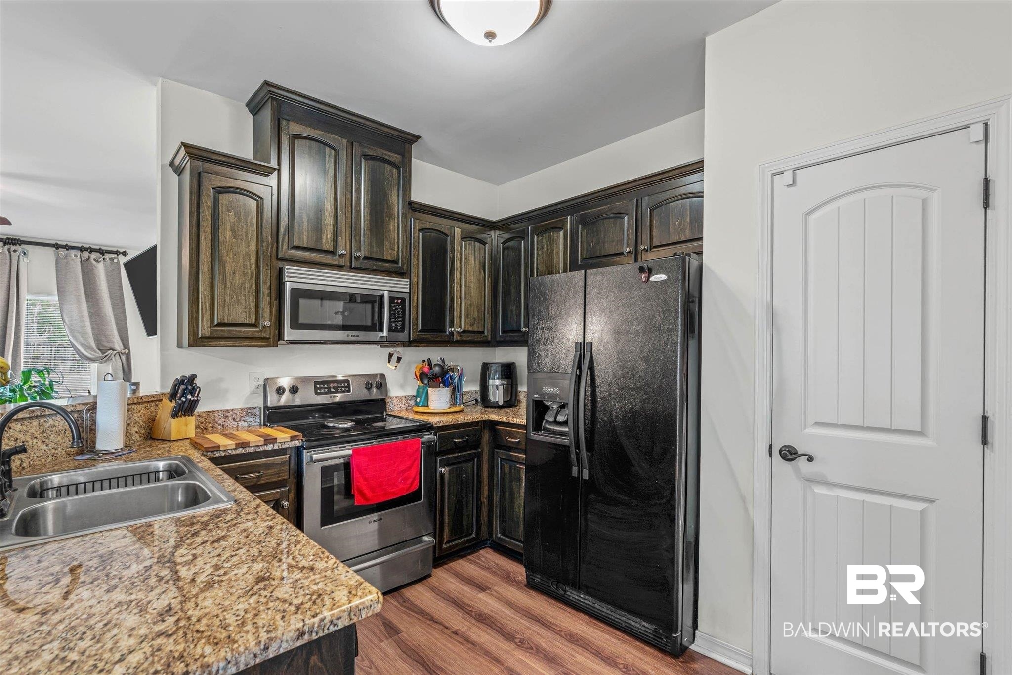 800 Galoway Avenue Mobile, AL 36609 - Photo 7 of 22 Kitchen featuring wood-finish cabinetry, speckled countertops, stainless steel appliances, and wood-finish flooring