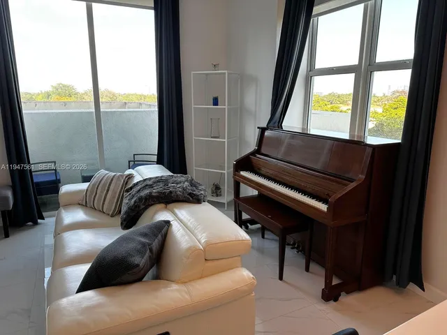 a living room with furniture and a floor to ceiling window