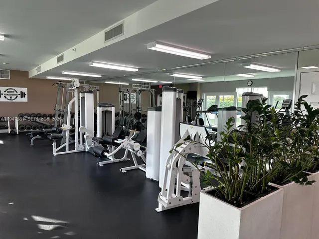a room with gym equipment and large mirror