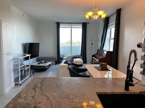 a living room with furniture chandelier and a flat screen tv