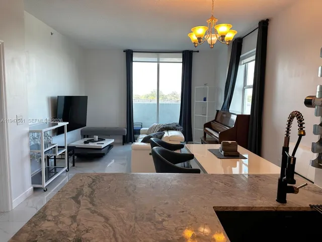 a living room with furniture chandelier and a flat screen tv