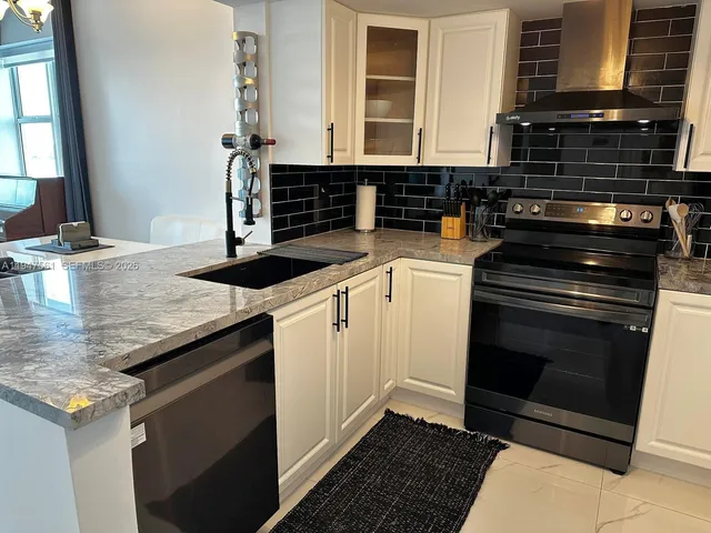 a kitchen with granite countertop a stove and a sink