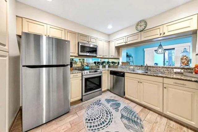 a kitchen with stainless steel appliances a refrigerator sink and microwave