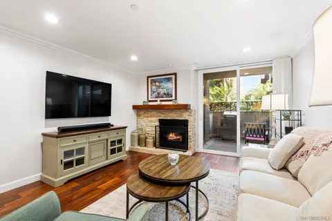 a living room with furniture a flat screen tv and a fireplace