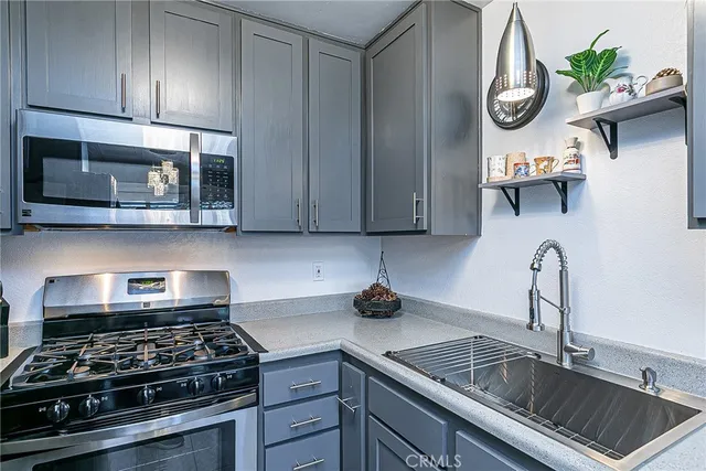 a kitchen with stainless steel appliances granite countertop a sink stove and cabinets