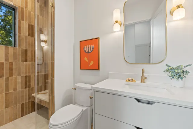a bathroom with a sink vanity mirror and toilet