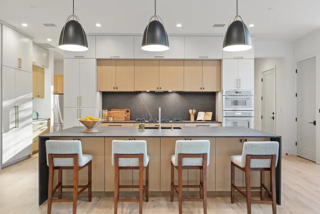 a kitchen with stainless steel appliances a stove a sink a refrigerator and cabinets