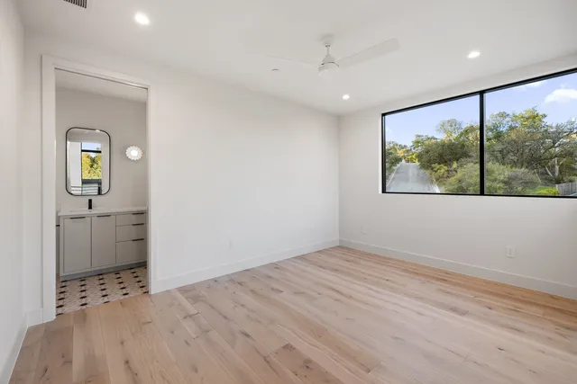 a view of hallway with a large window and wooden floor