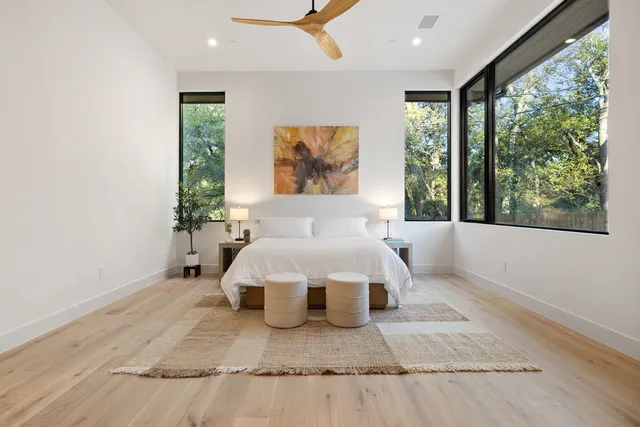 a bed sitting in a spacious bedroom next to a window