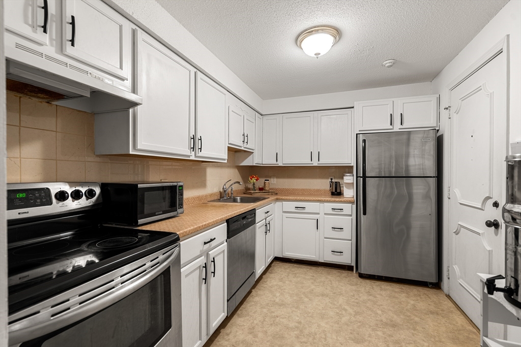 181 Littleton Road, Unit 134 Chelmsford, MA 01824 - Photo 7 of 20 a kitchen with white cabinets and white appliances