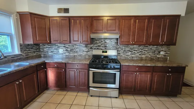 a kitchen with granite countertop wooden cabinets and stainless steel appliances
