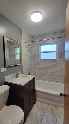 a bathroom with a double vanity sink toilet mirror and bathtub