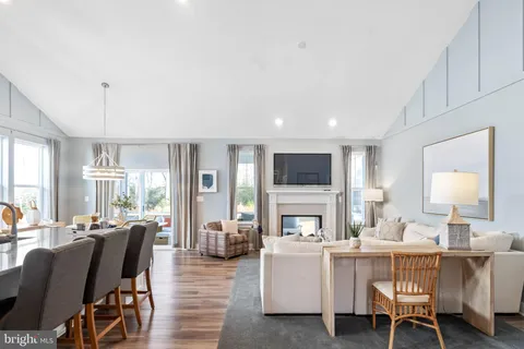 a kitchen with stainless steel appliances granite countertop a stove top oven a sink dishwasher a dining table and chairs with wooden floor