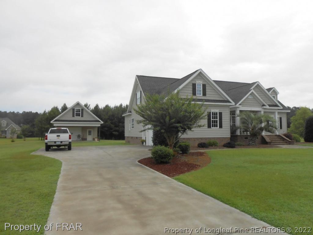 6257 Howell Road Lumberton, NC 28358 - Photo 11 of 34 a front view of a house with a garden and yard