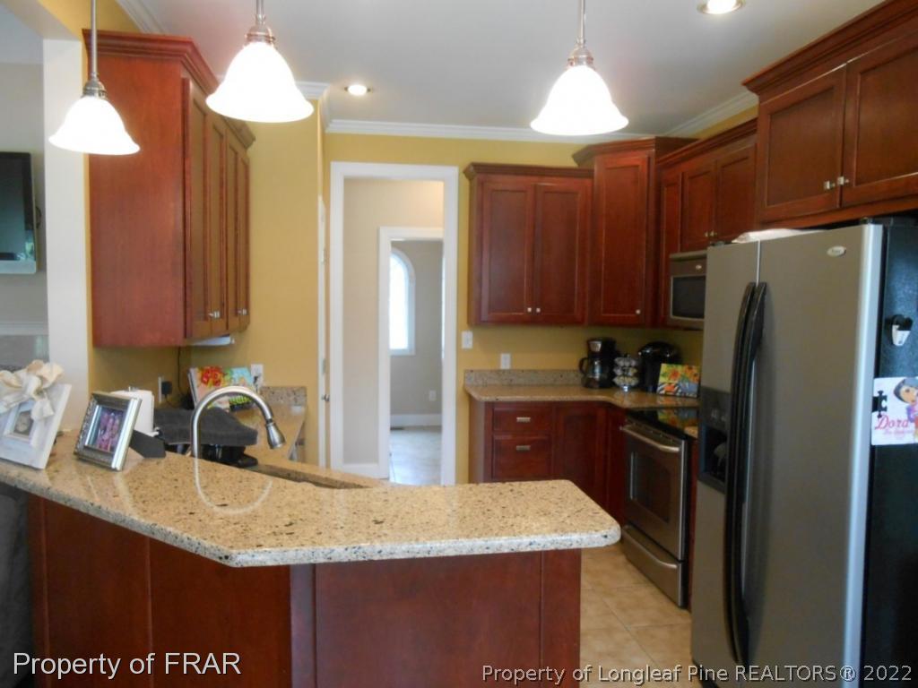 6257 Howell Road Lumberton, NC 28358 - Photo 17 of 34 a kitchen with stainless steel appliances granite countertop a sink refrigerator and cabinets