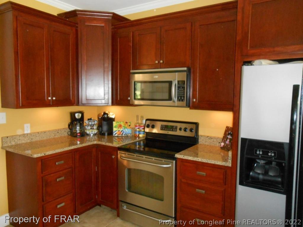 6257 Howell Road Lumberton, NC 28358 - Photo 19 of 34 a kitchen with granite countertop wooden cabinets and stainless steel appliances