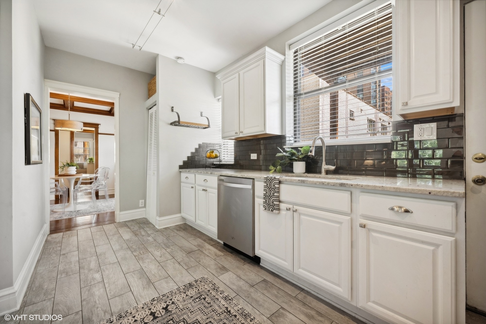 3749 North Pine Grove Avenue, Unit 3 Chicago, IL 60613 - Photo 13 of 18 a kitchen with white cabinets and wooden floor