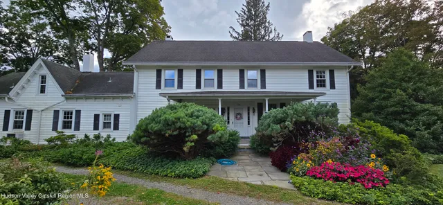 a front view of a house with a yard and garden