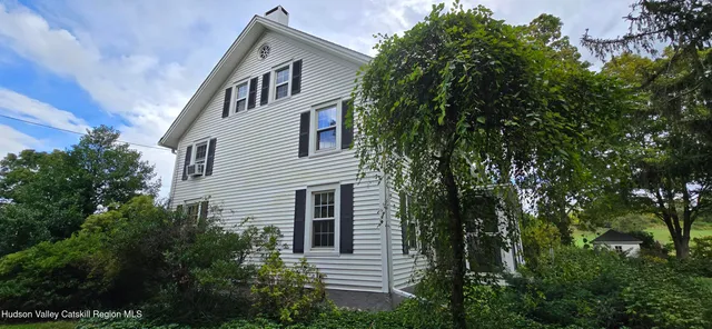 a front view of a house with a tree