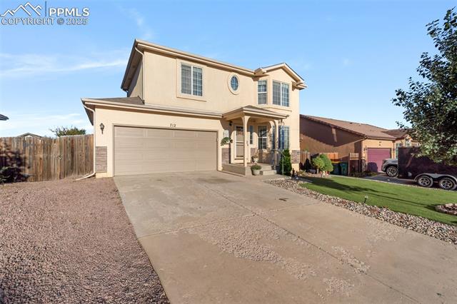 712 Rye Ridge Road Fountain, CO 80817 - Photo 4 of 45 Traditional-style house featuring stucco siding, concrete driveway, a garage, and a porch