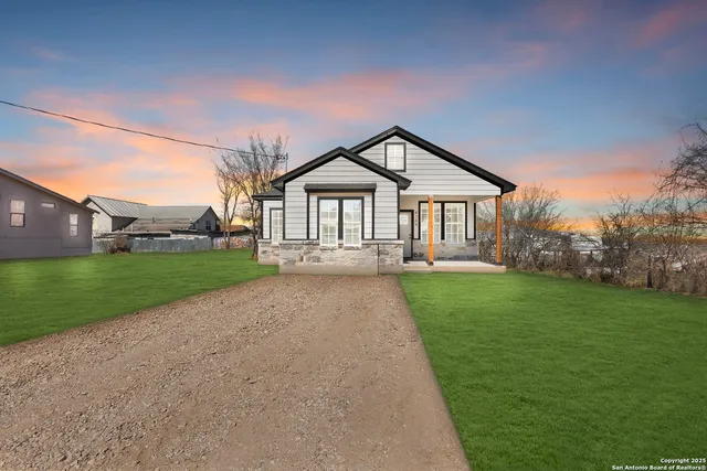 a view of house with a big yard and large trees