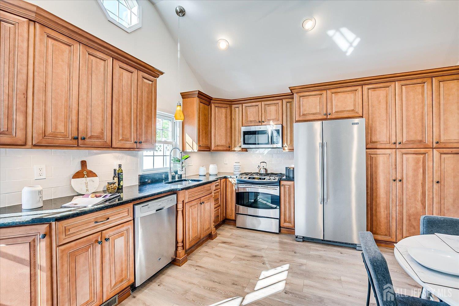 341 Victor Place Neptune, NJ 07753 - Photo 17 of 45 a kitchen with stainless steel appliances granite countertop a refrigerator a sink dishwasher a stove top oven a refrigerator with white cabinets and wooden floor
