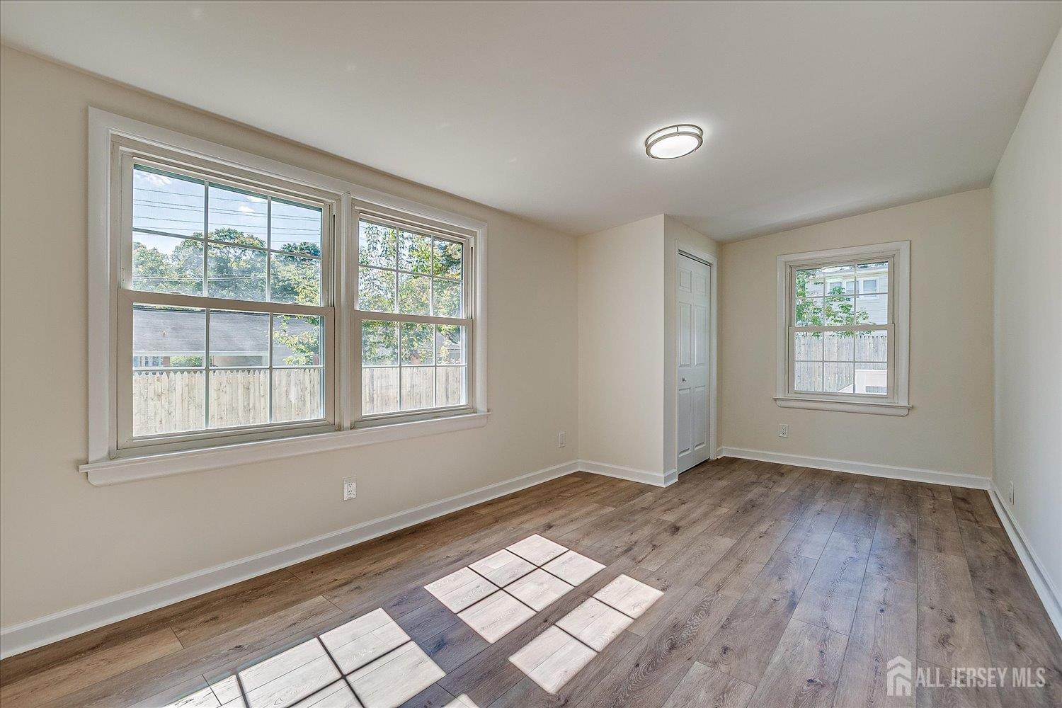 341 Victor Place Neptune, NJ 07753 - Photo 26 of 45 an empty room with wooden floor and windows